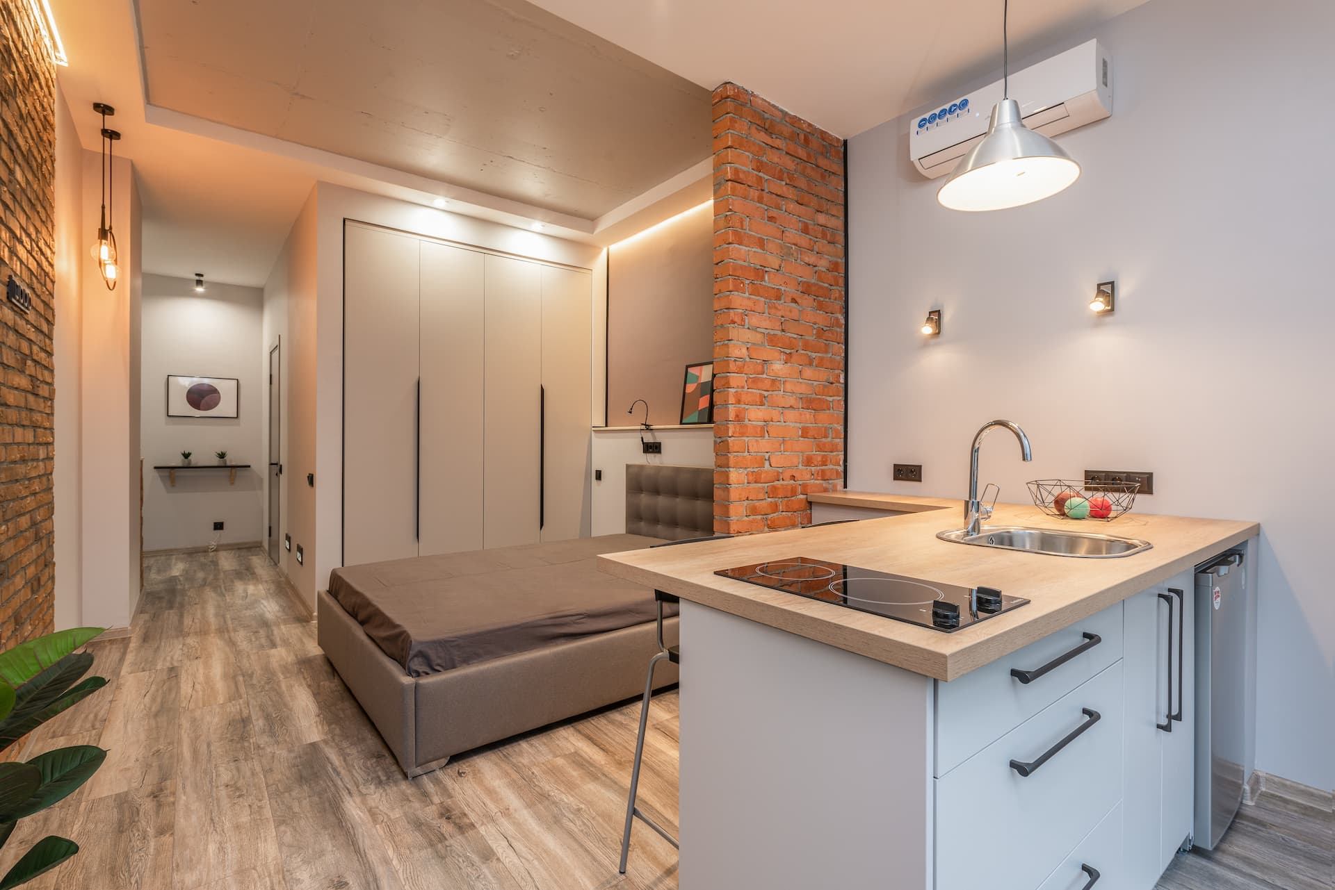 Piso de soltero decorado con pared de ladrillos vistos